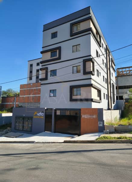 Fachada moderna de prédio com janelas geométricas e portão preto. Arquitetura urbana.