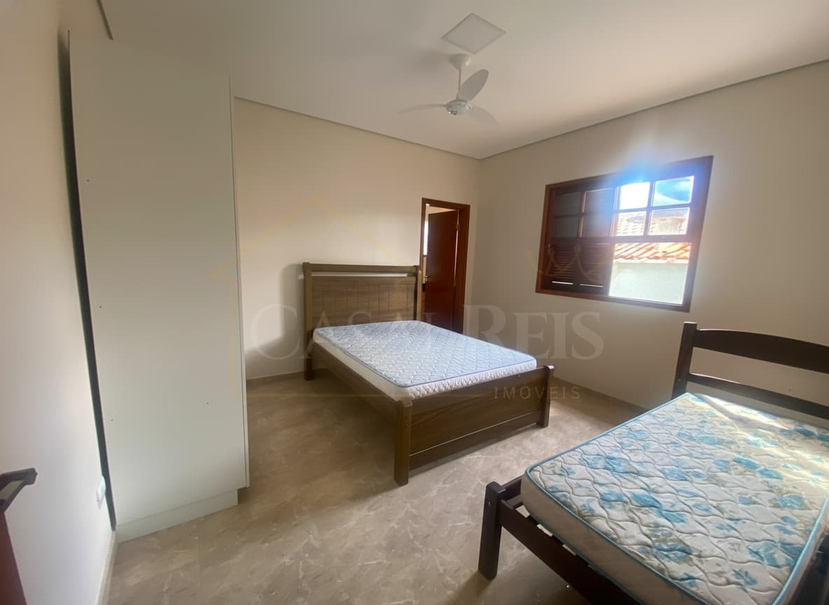 Quarto com duas camas de madeira, armário branco e piso de mármore. Janela com luz solar.